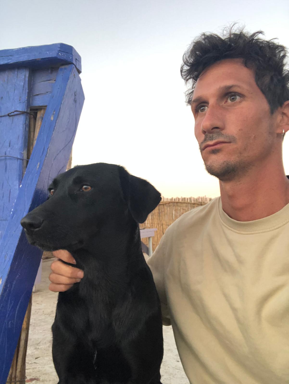 Portrait avec un chien noir, en bord de mer